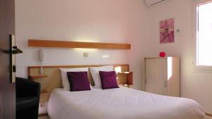 巴布通莱班奥伯盖德酒店的卧室配有一张带紫色枕头的大型白色床。