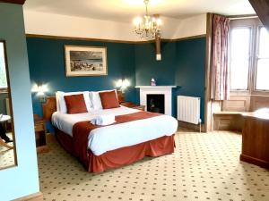 斯沃尼奇波贝克路易莎酒店的一间卧室设有一张大床和一个壁炉