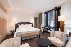 卡罗纳Villa Carona Hotel & Spa的酒店客房带一张床、一张桌子和椅子