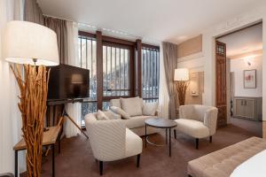 卡罗纳Villa Carona Hotel & Spa的客厅配有沙发、椅子和电视