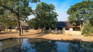DeteGwango Elephant Lodge的前面有池塘的房子
