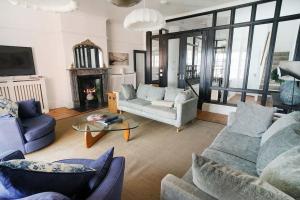 考斯Woodyear House - Cowes - Sleeps 8 - 4 Bed - Dog Friendly - Waterfront的客厅配有两张沙发和一张桌子