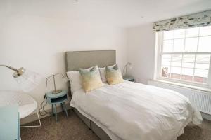 考斯Woodyear House - Cowes - Sleeps 8 - 4 Bed - Dog Friendly - Waterfront的白色的卧室设有床和窗户