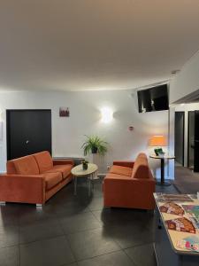 加来Logis Cottage Hôtel的客厅配有2张橙色沙发和1张桌子