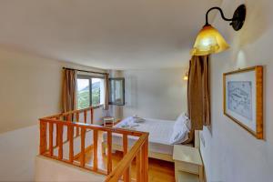 AchladaMourtzanakis Residence - Traditional Eco Hotel in Achlada的一间卧室设有一张床,楼梯设有窗户