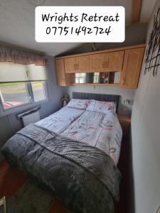 Saint CyrusWrights Retreat 4 Lunan View St Cyrus Caravan Park的一间小房间的卧室,配有一张床铺