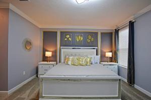 基西米Amazing 6BR Villa @ Storey Lake Resort Near Disney的一间卧室配有一张大床、两张桌子和两盏灯。