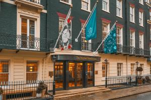 伦敦The Mayfair Townhouse - an Iconic Luxury Hotel的前面有旗帜的建筑