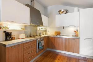 DorioBernhouse的厨房配有白色橱柜和木地板。