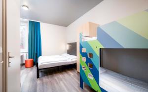 维也纳维也纳施塔特哈勒A&O经济型连锁酒店 的一间小房间,配有一张双层床,一间卧室配有一张床