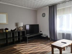 ExhallCharming spacious 2 bed apartment in quiet area的客厅配有平面电视和桌子。