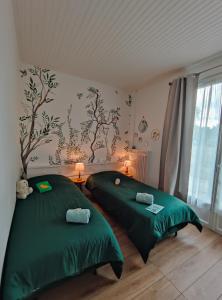 ÉvryAtelier des sens 89的配有绿床单的客房内的两张床