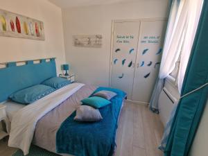 科利尤尔location Coma Chéric et parking的一间卧室配有一张带蓝色床单和枕头的床。