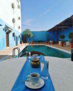 Sidi Abd el KaderRiad Freija-TAROUDANT的一张桌子,上面有一杯咖啡,放在蓝色的桌布上