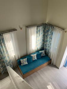 锡米Aleminas Rooms的窗户客房内的蓝色沙发