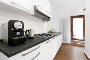 DorioCasa Leonardo的厨房配有白色橱柜和黑色台面