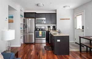 特拉弗斯城Midtown Condo 9 Great Traverse City Location的厨房配有不锈钢用具,铺有木地板