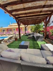 拉戈斯Vila Graciosa - Tranquility Oasis的一个带木凉棚下沙发的庭院