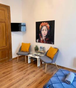 克拉科夫Topolove Rooms & Apartments的客厅配有两把椅子和一幅女画