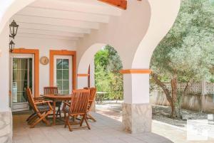卡尔佩Villa Angeles - Grupo Turis的庭院配有木桌和椅子