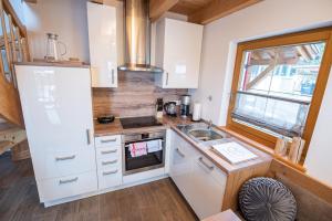 莱希布鲁克Hirsch Chalet #Sauna的小厨房配有白色橱柜和水槽