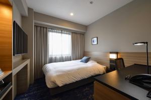 宫崎宫崎市酒店的配有一张床和一张书桌的酒店客房