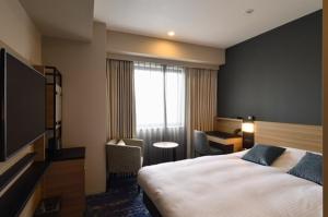 宫崎宫崎市酒店的一间设有大床和窗户的酒店客房