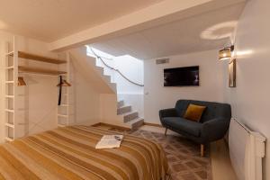 滨海卡涅渔夫公寓的一间卧室配有一张床、一把椅子和楼梯。