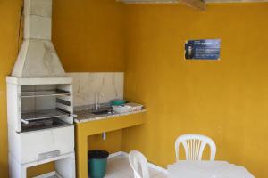 卡波布里奥Kitnet Apto em Cabo Frio RJ - Recanto das Corujas的一间带水槽和炉灶的小厨房