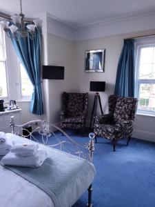 本布里奇The Birdham At Bembridge的一间卧室配有一张床和两把椅子