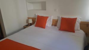 西尔韦斯Al-Xelb guesthouse的一间卧室配有带橙色和白色枕头的床