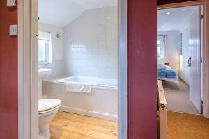 黑尔斯沃思Ivy House Mells的带浴缸和卫生间的浴室以及1张床。