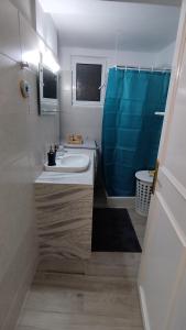 阿彻奇洛斯Sea Breeze的浴室设有水槽和蓝色的浴帘