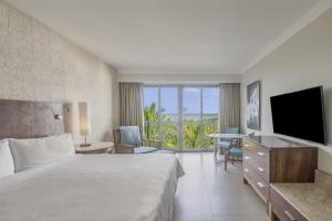 坎昆Fiesta Americana Condesa Cancun - All Inclusive的酒店客房,配有床和电视