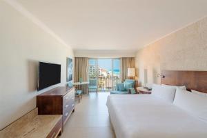坎昆Fiesta Americana Condesa Cancun - All Inclusive的酒店客房,配有床和电视