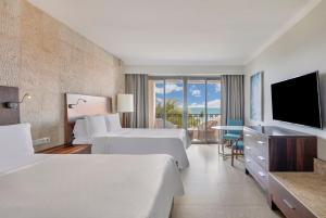 坎昆Fiesta Americana Condesa Cancun - All Inclusive的酒店客房设有两张床和一台平面电视。