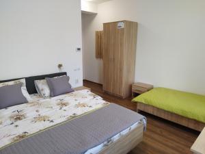 萨图马雷Pensiunea Florilor Satu Mare的一间卧室设有两张床和绿色的橱柜