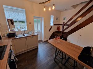 斯基普顿Albert Cottage的厨房配有水槽和木桌