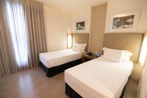 贝洛奥里藏特H2 Platinum Lourdes的酒店客房设有两张床和窗户。