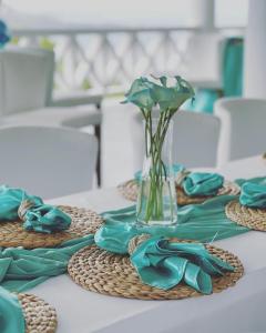 BelmontBay House Grenada的一张带蓝色餐巾的桌子和一个花瓶