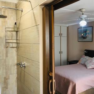 德班JoThams Bed & Breakfast or Self-catering的一间卧室设有淋浴、一张床和淋浴。