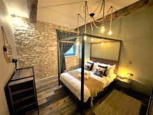 MarskeMarske Stables, Yorkshire Dales的一间卧室设有天蓬床和砖墙