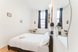 伦敦Bethnal Green beds to stay的白色卧室配有床和镜子