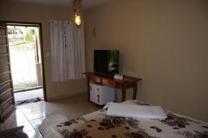 MaranguapeSítio Vale da Serra的一间卧室配有一张床和一张桌子上的电视