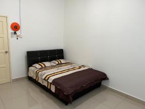 Pontian BesarDe Pontian Homestay的白色墙壁间的一张床位