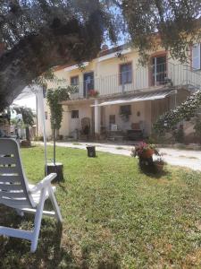 费尔莫La Voce della Natura的坐在房子的院子中的白色椅子