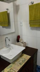 莫罗圣保罗Casa aconchegante ampla e charmosa的浴室设有白色水槽和绿色毛巾。