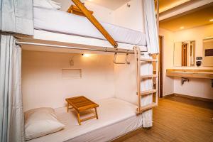 坎昆Nomads Party Hostel的客房设有两张双层床和一张桌子。