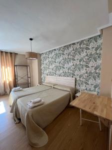 雷诺萨塔哈耶罗住宿加早餐旅馆的一间卧室配有一张大床和一张桌子