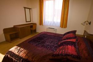 凯希道库什塔尼萨瑞德赛玛克佩泽欧酒店的一间卧室配有一张带红色棉被的床和窗户。